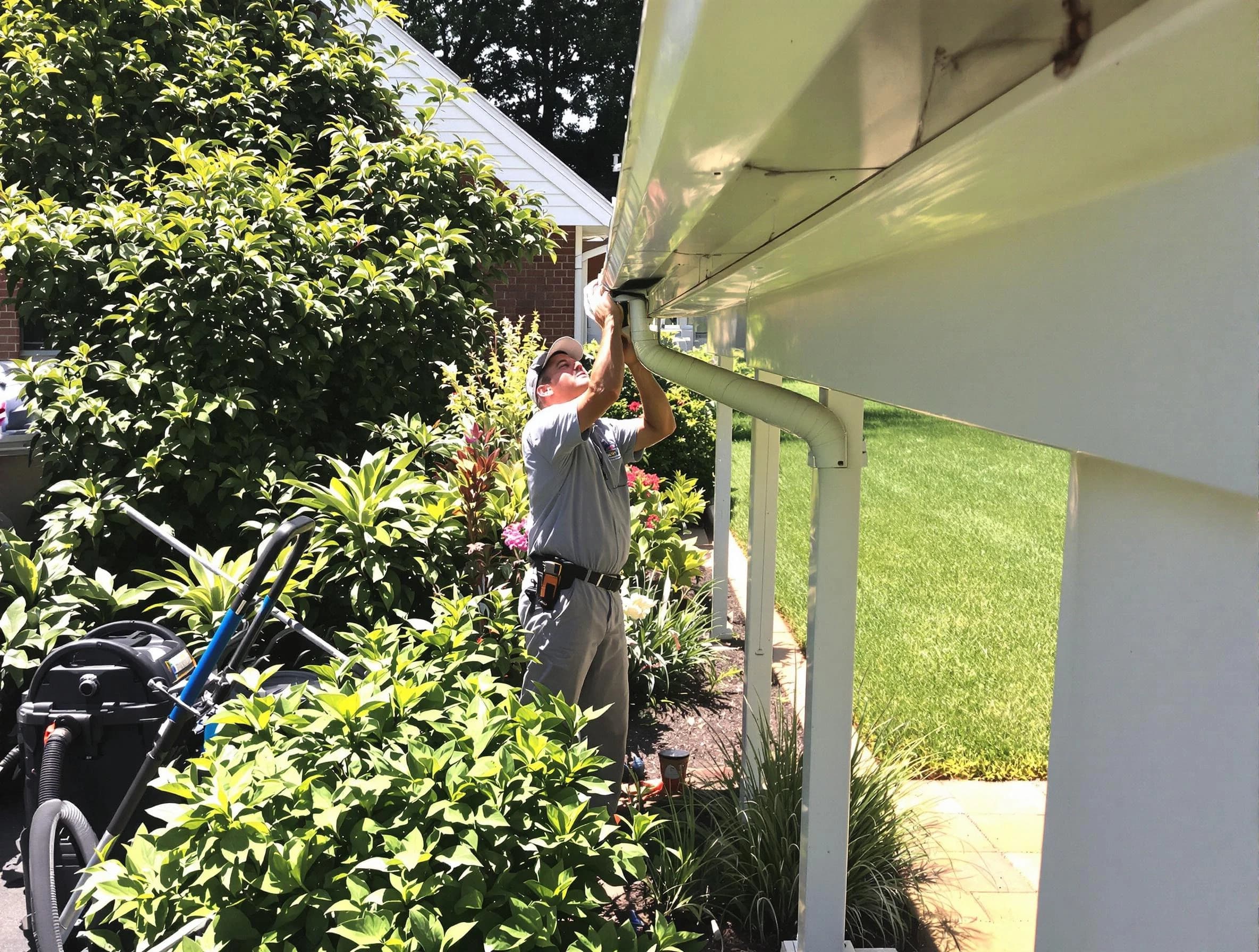 Technician flushing a blockage from a downspout in Stow, OH